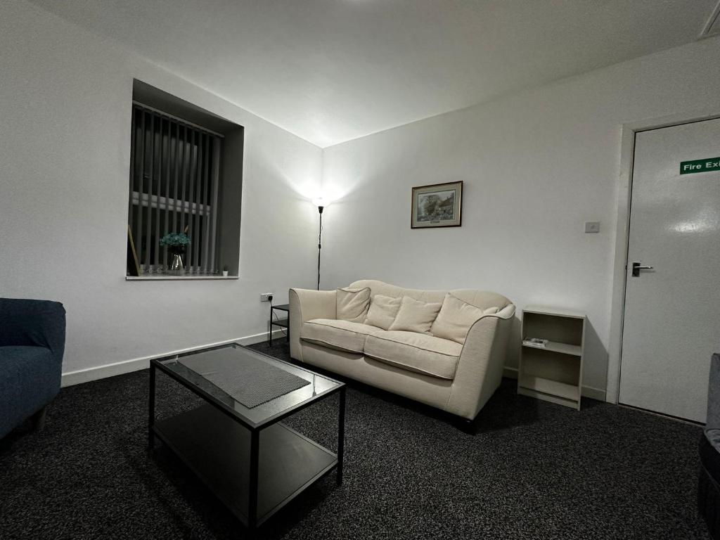 a living room with a couch and a table at Blackwood Residence in Accrington