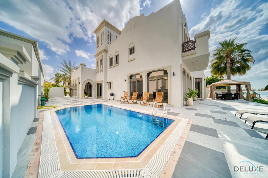 una piscina en el patio trasero de una casa en Seaside 5BR Villa with Assistant's Room and Beach Access on Palm Jumeirah by Deluxe Holiday Homes, en Dubái