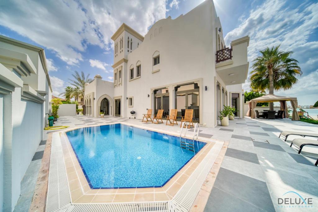 a pool in the backyard of a house at Seaside 5BR Villa with Assistant's Room and Beach Access on Palm Jumeirah by Deluxe Holiday Homes in Dubai