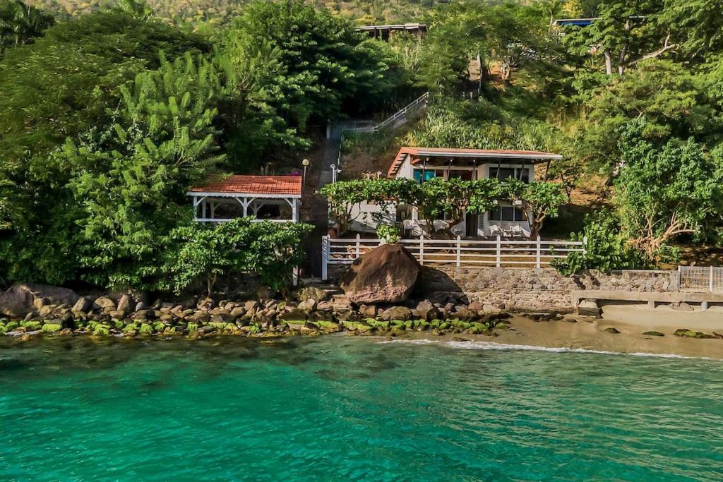 a house on the shore of a body of water at Villa Fleur D'eau in Grande Anse