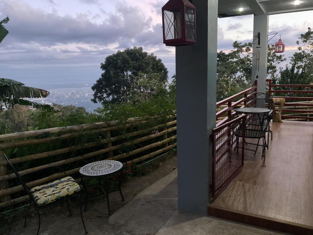 a balcony with two chairs and a table and a view at Anza Cabin at Threesome Cafe in Cebu City