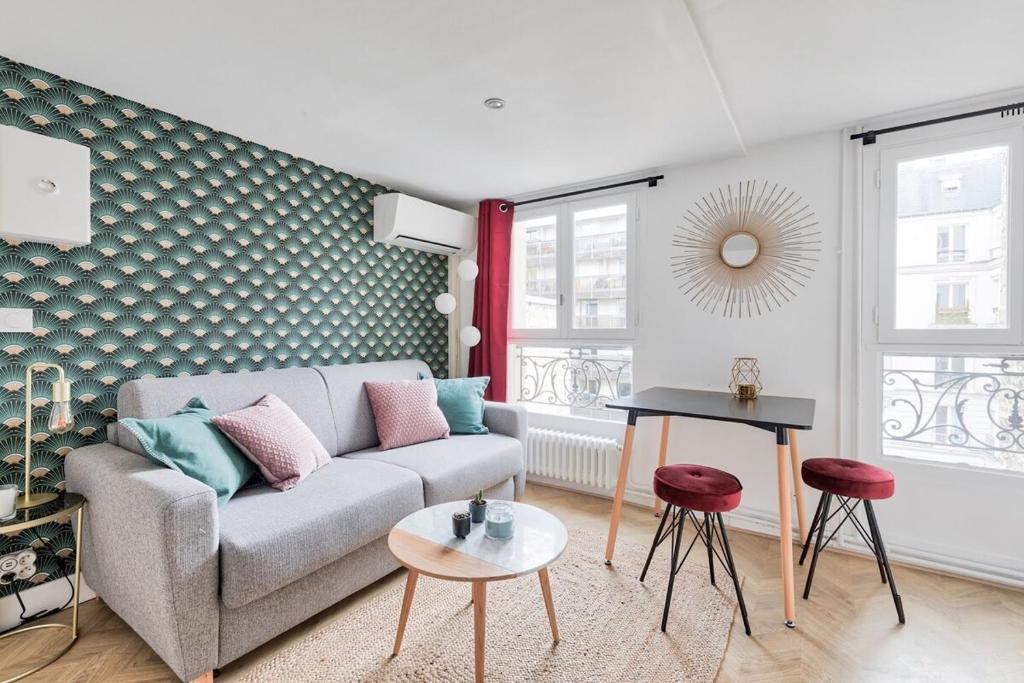 una sala de estar con un sofá y una mesa en Appartement d'architecte proche Arc de Triomphe-2P, en París