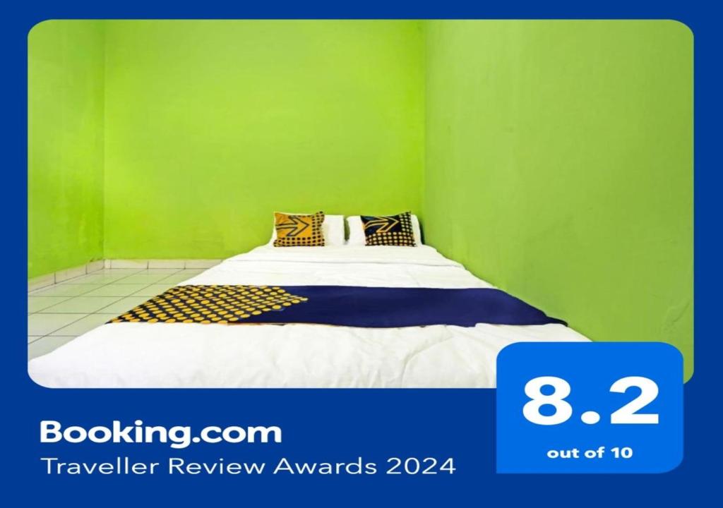 a bedroom with a bed with green walls at SPOT ON 91325 Pondok Hijau Guest House Syariah in Cilimus 2