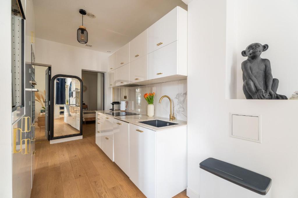 a white kitchen with white cabinets and a sink at Charmant appartement haut de gamme in Bordeaux