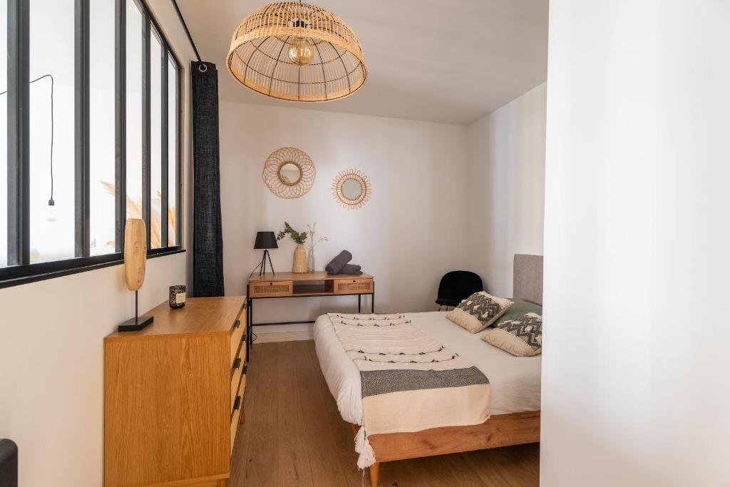 a bedroom with a bed and a desk and a window at Charmant appartement haut de gamme in Bordeaux