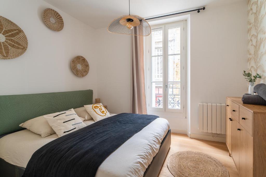 a bedroom with a bed and a large window at Charmant appartement haut de gamme in Bordeaux