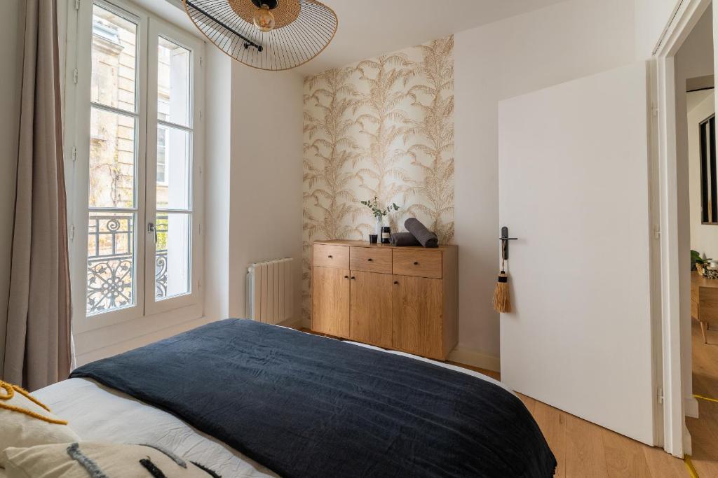 a bedroom with a bed and a window at Charmant appartement haut de gamme in Bordeaux