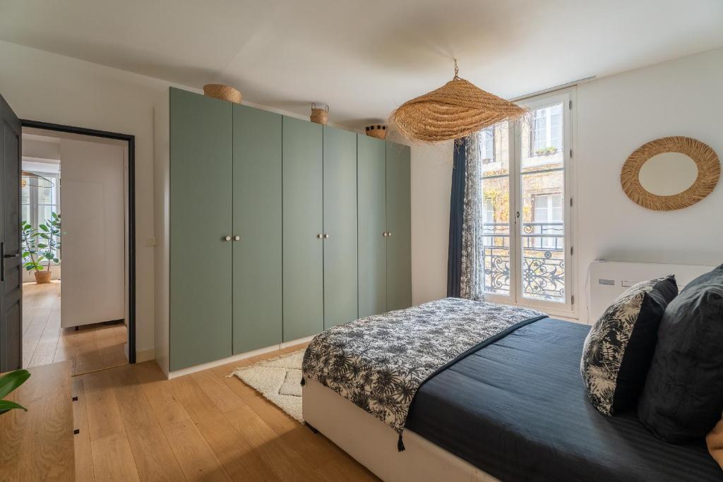 a bedroom with a bed and a large window at Charmant appartement haut de gamme in Bordeaux