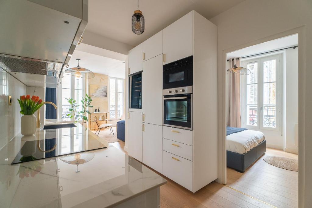 a large white kitchen with a glass counter top at Charmant appartement haut de gamme in Bordeaux