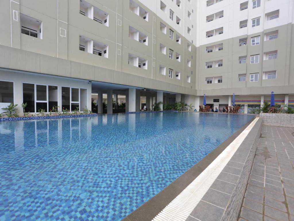 a large swimming pool in front of a building at Aurora Rooms @ Apartemen Loftvilles City in Dukuh