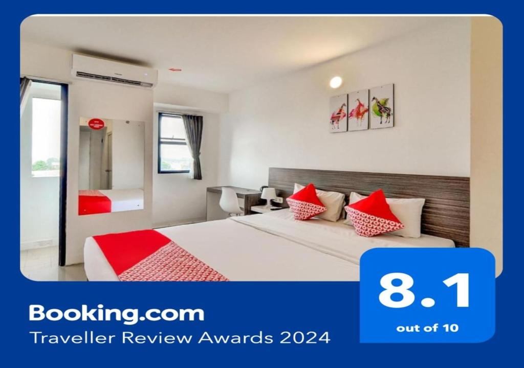 ein Hotelzimmer mit einem Bett mit roten Kissen in der Unterkunft Collection O 92440 Urban Town Apartment Karawang in Telukjambe