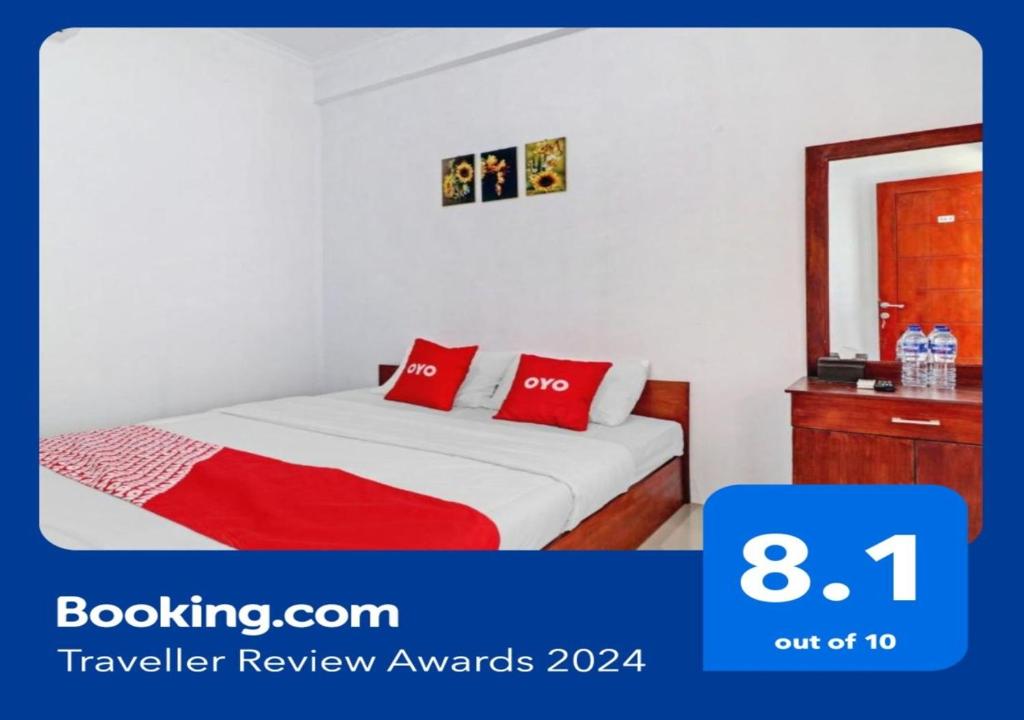 um quarto com uma cama com almofadas vermelhas em OYO Life 90570 Heboh Guest House Syariah em Ciwalengka