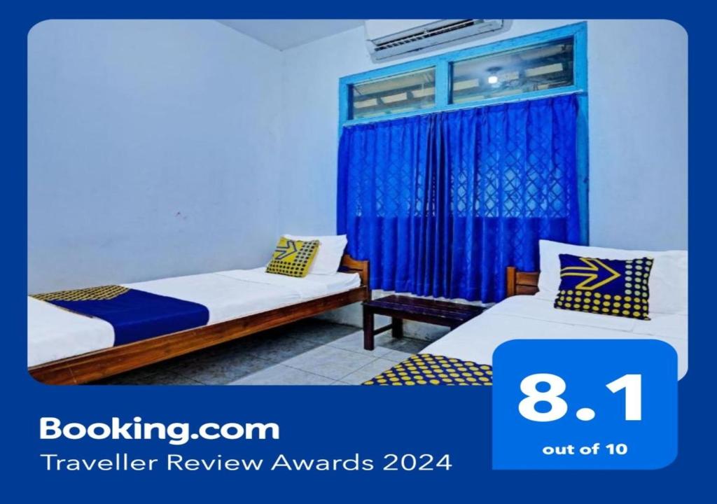 een hotelkamer met 2 bedden en een raam bij SPOT ON 2275 Omah Jm in Beran-kidul