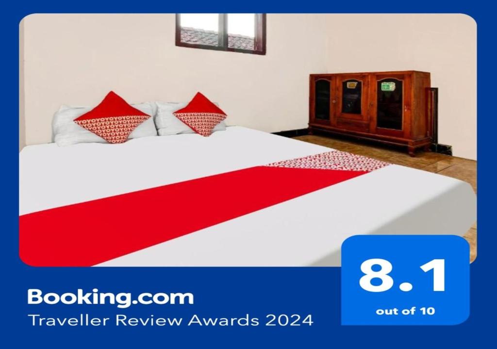 1 dormitorio con 1 cama con sábanas rojas y blancas en OYO Homes 91134 Desa Wisata Tebing Lingga 