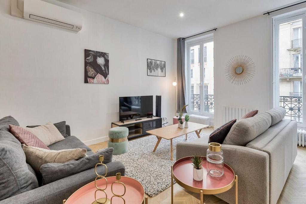 a living room with a couch and a tv at Appartement luxueux proche Arc-de-Triomphe - 4P in Paris