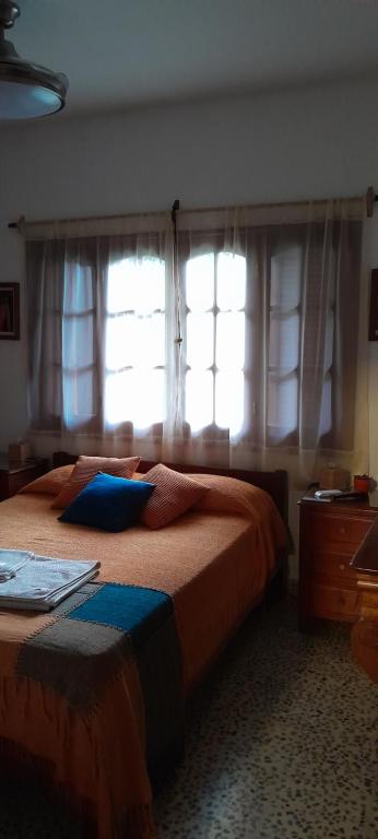 Schlafzimmer mit einem Bett und einem Fenster mit Vorhängen in der Unterkunft Rancho Aparte II in Salta