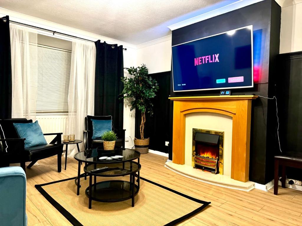 a living room with a tv and a fireplace at Rooms Near Me - Worcester, Sky Tv, Free Double Parking in Worcester