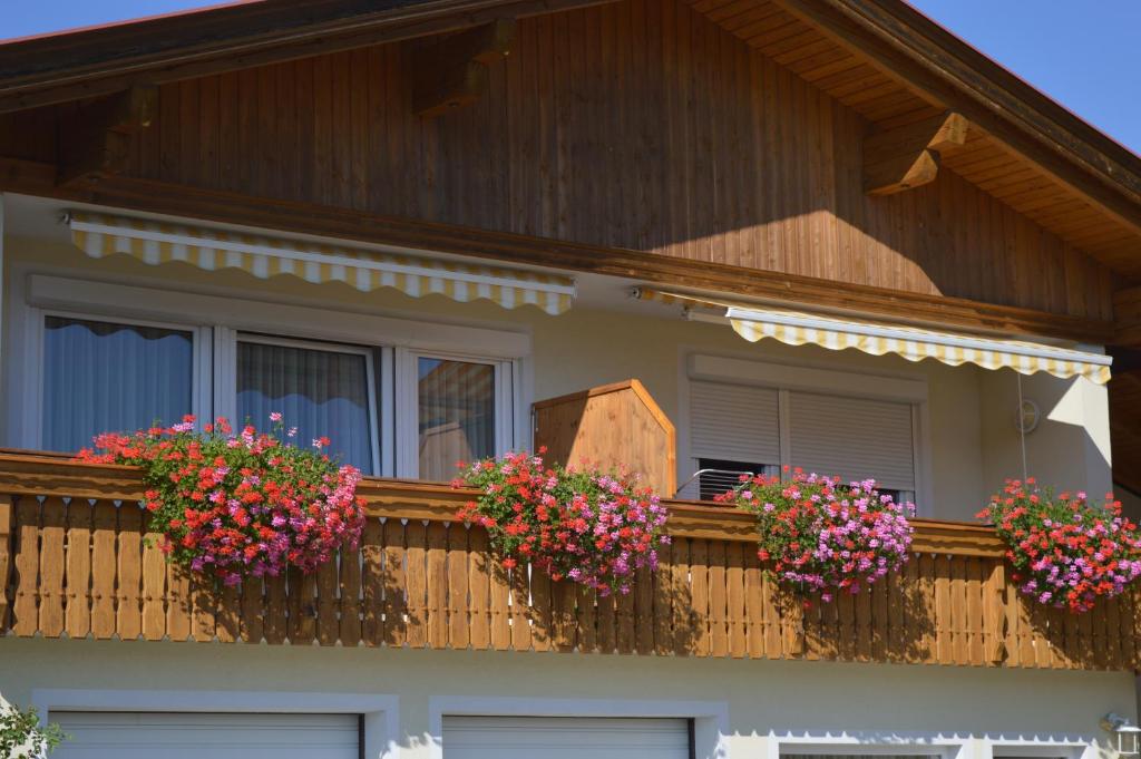 a house with flower boxes on a balcony at Appartements Kuchler in Velden am Wörthersee