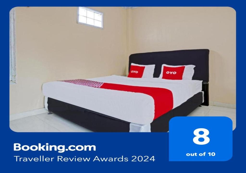 a bedroom with a bed with red pillows at OYO 90416 Wisma Wayang Ajen Syariah in Subang