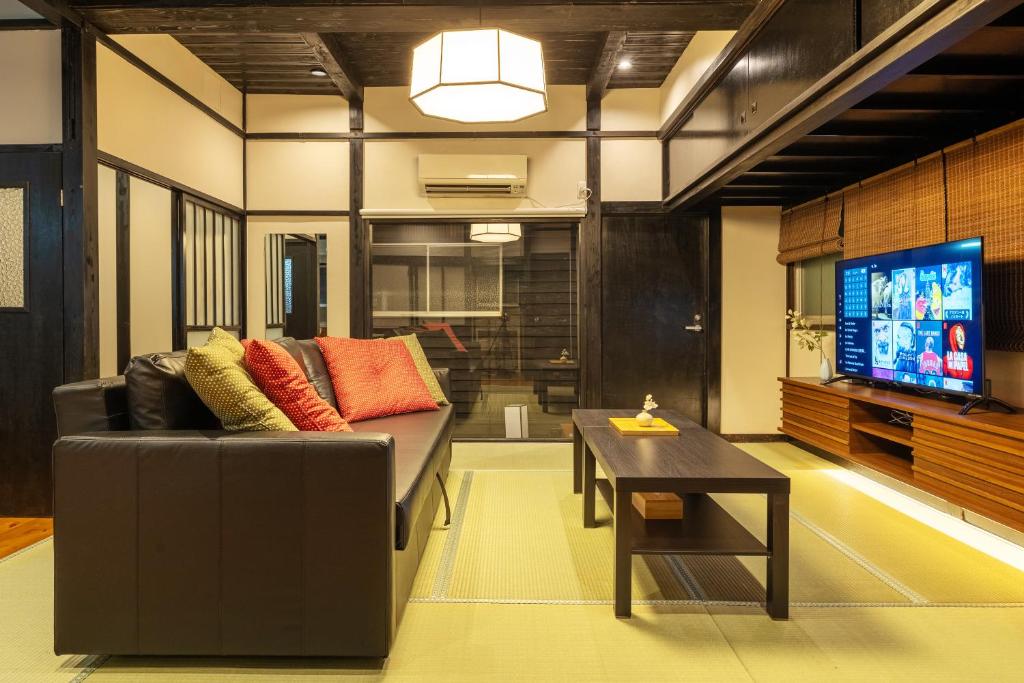 a living room with a couch and a tv at SKY GATEスカイツリー徒歩3分の貸切ヴィラ/成田羽田直通/浅草徒歩15分 in Tokyo