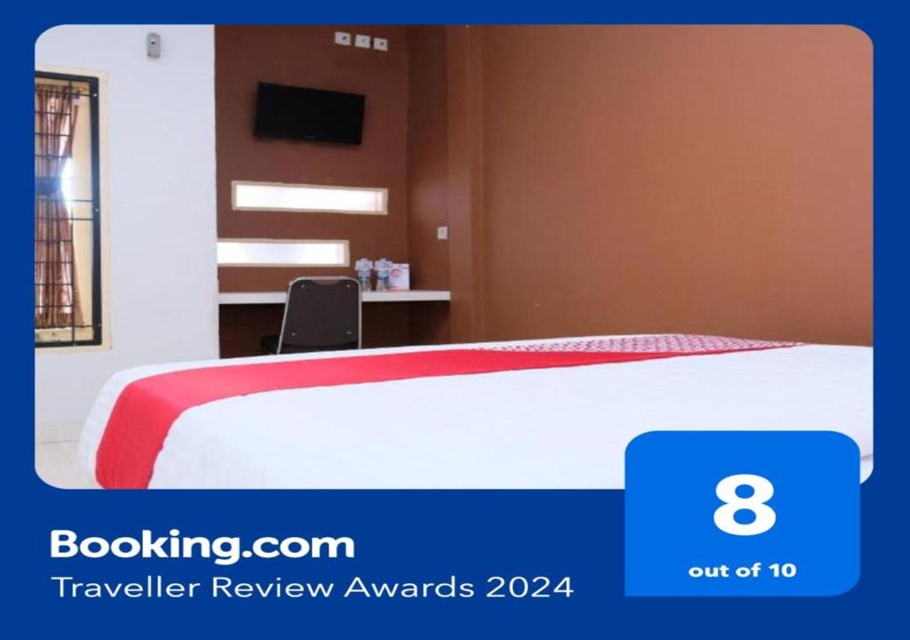 una camera d'albergo con un letto con una coperta rossa di SUPER OYO 811 Mars Kost Syariah a Jambi