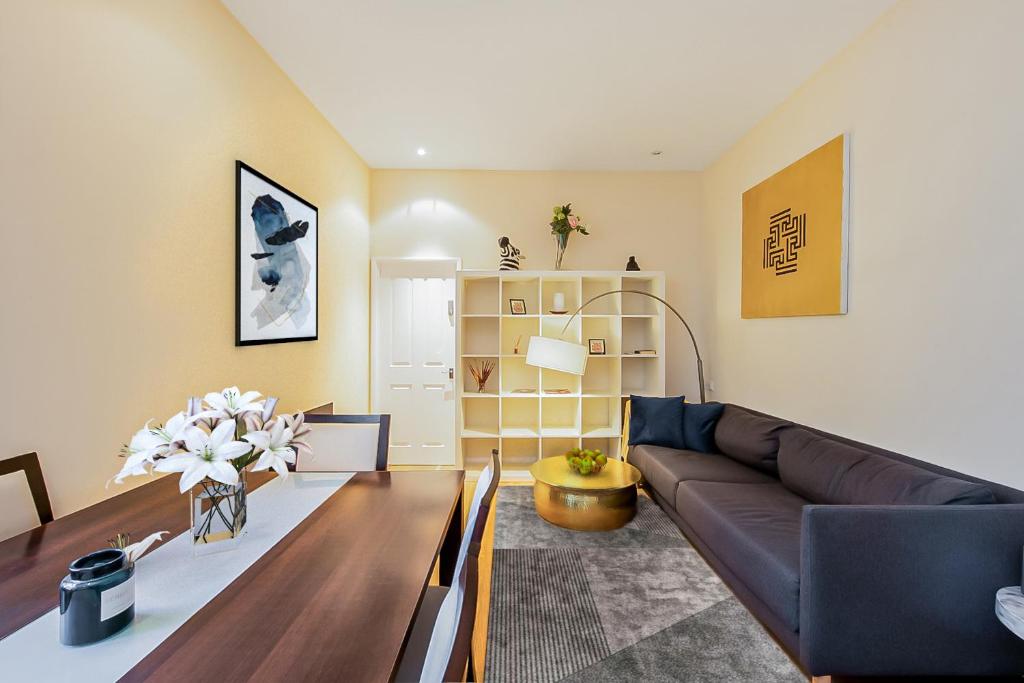 a living room with a couch and a table at Pollen Street, Three-bedroom Flat in London