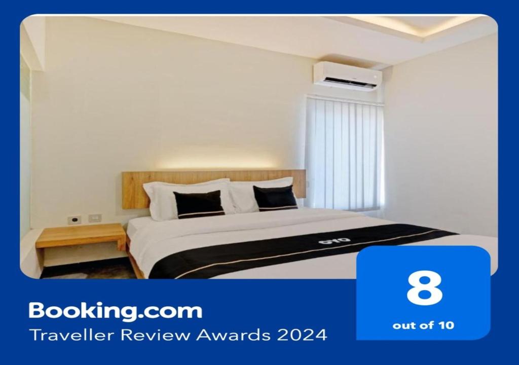 a hotel room with a bed and avertisement at OYO Capital O 90410 Griya Amanah Jajar Syariah in Solo