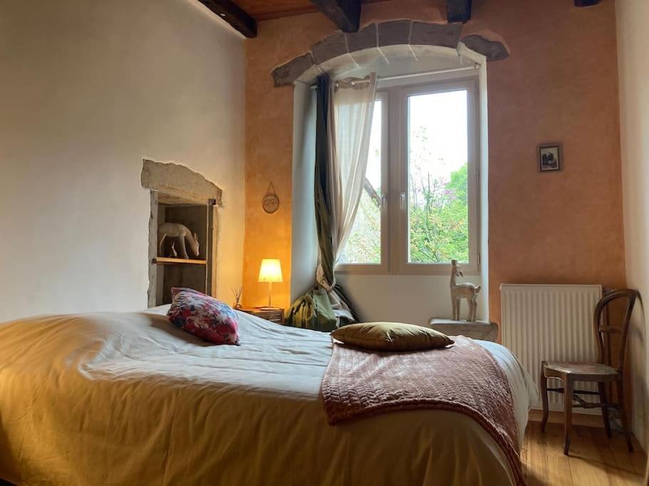 Un dormitorio con una cama grande y una ventana en La nuit de la chouette, en Bruniquel