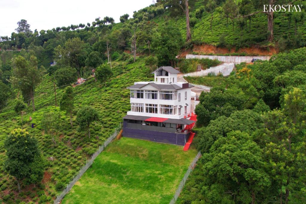 烏蒂的住宿－EKOSTAY I Pearl House Villa I 360 Degrees Tea Estate，山丘上大房子的空中景色