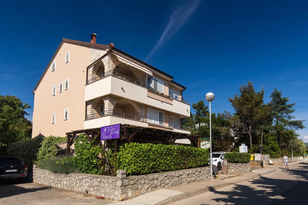 um edifício alto numa rua com um céu azul em Bed & Breakfast Mario em Krk