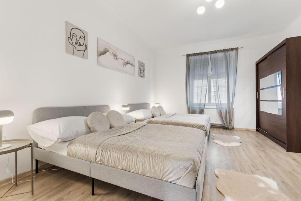 a white bedroom with a large bed and a window at City Center Suite - Modern & Stylish in Bratislava