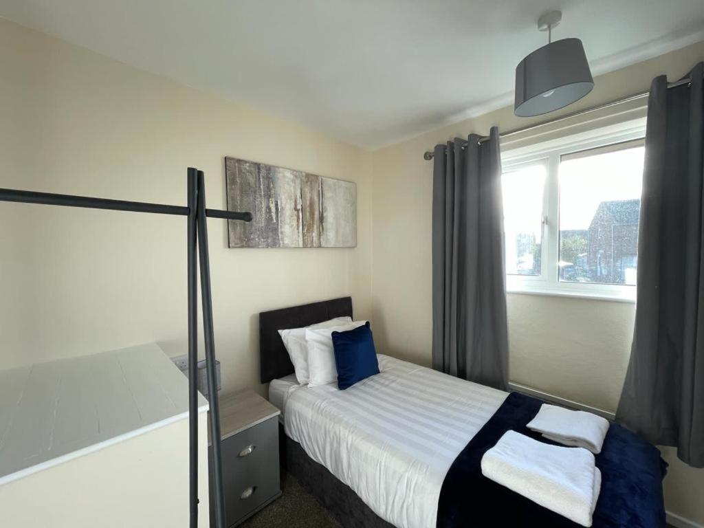 um quarto de hotel com uma cama e uma janela em Stunning 3 bedrooms house with Garden and Free Parking em Barnsley