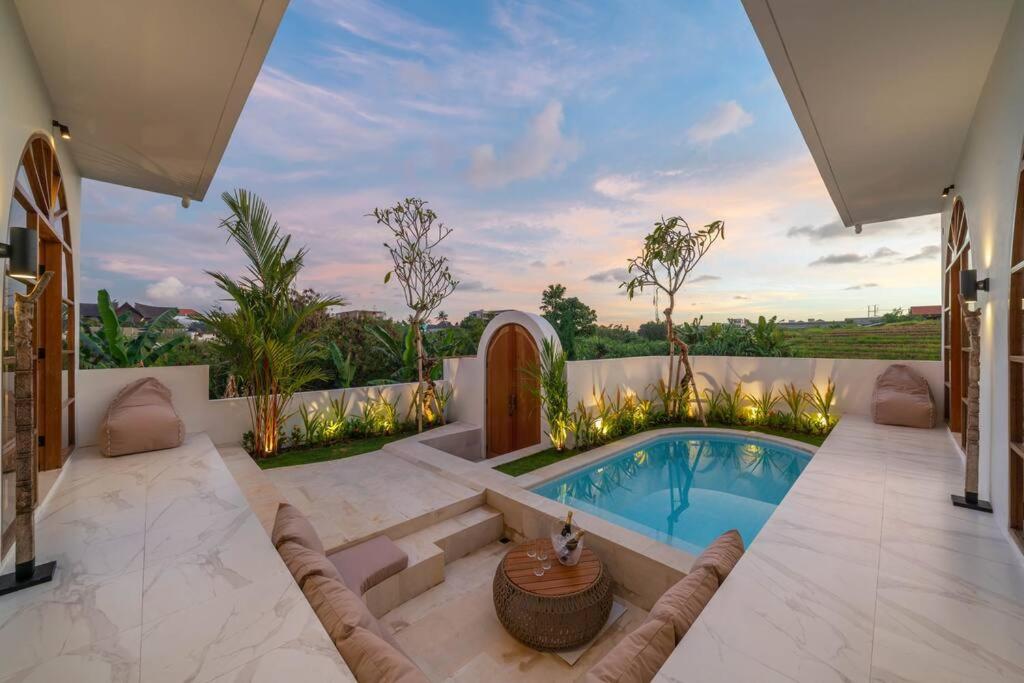 een huis met een zwembad in een tuin bij Villa AMARYA - NEW Tropical & Modern 3BR Central - Canggu beach in Canggu