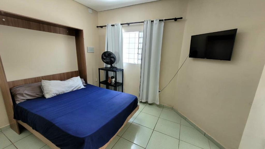 een slaapkamer met een bed en een flatscreen-tv bij Shekinah in Sumaré