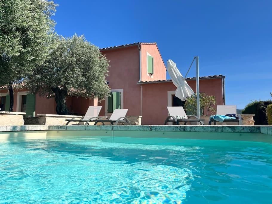 uma piscina com cadeiras e uma casa em Villa 4-6 pers Luberon Côté Oliviers em Gargas