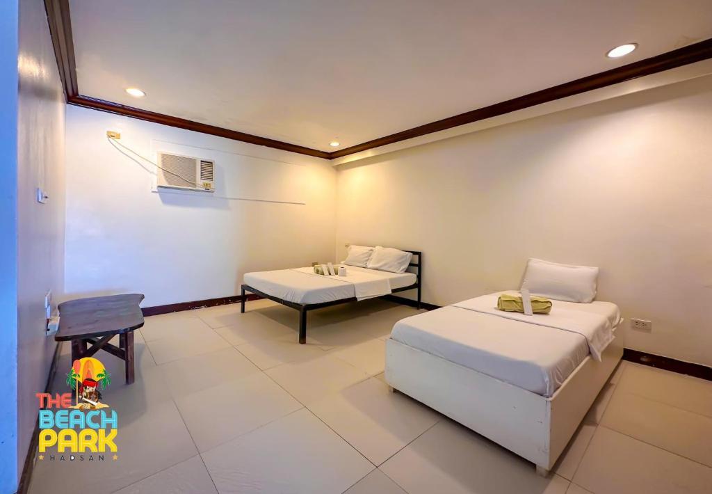 1 dormitorio con 2 camas, mesa y silla en Beach Side Room The Beach Park-Hadsan en Lapu Lapu City