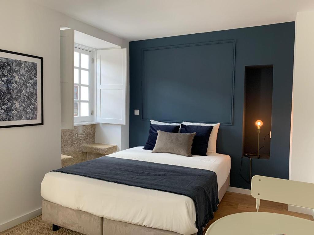 um quarto com uma cama grande e paredes azuis em Casa do Museu em Coimbra