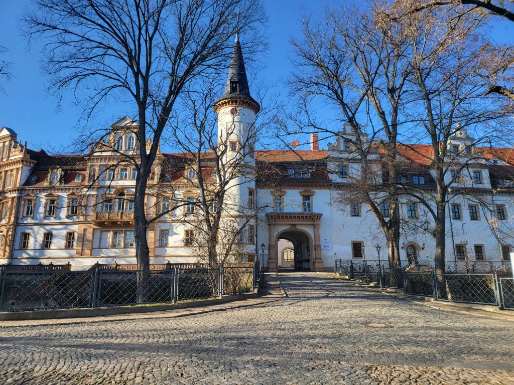 un gran edificio blanco con una torre de reloj en Hotel Schloss Schkopau en Schkopau