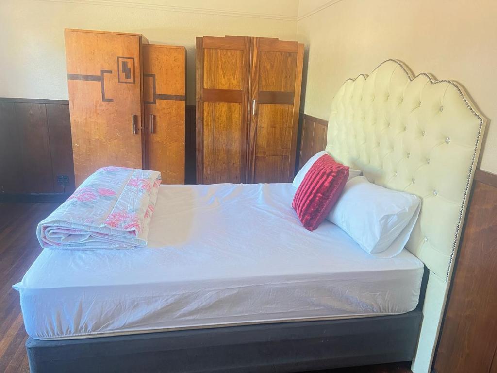 a bedroom with a bed with a white headboard and two pillows at tripple s guest house in Cape Town