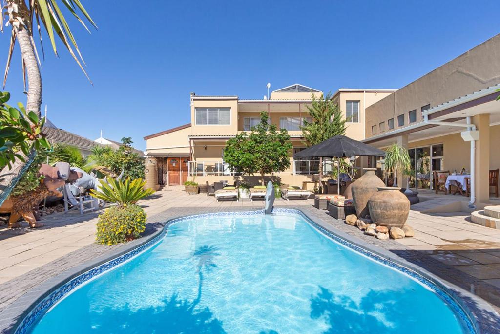 a swimming pool in front of a house at Kwantu Guesthouse 1 in Cape Town
