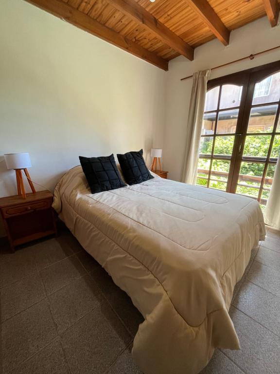uma cama grande num quarto com uma janela grande em Duplex 2 - Rama Caida em Pinamar