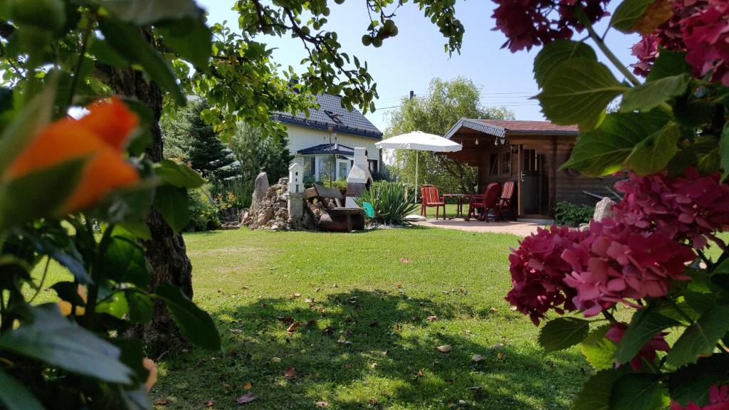 ein Haus mit einem Garten mit einem Tisch und Stühlen in der Unterkunft Ferienwohnung Veit in Pennewitz
