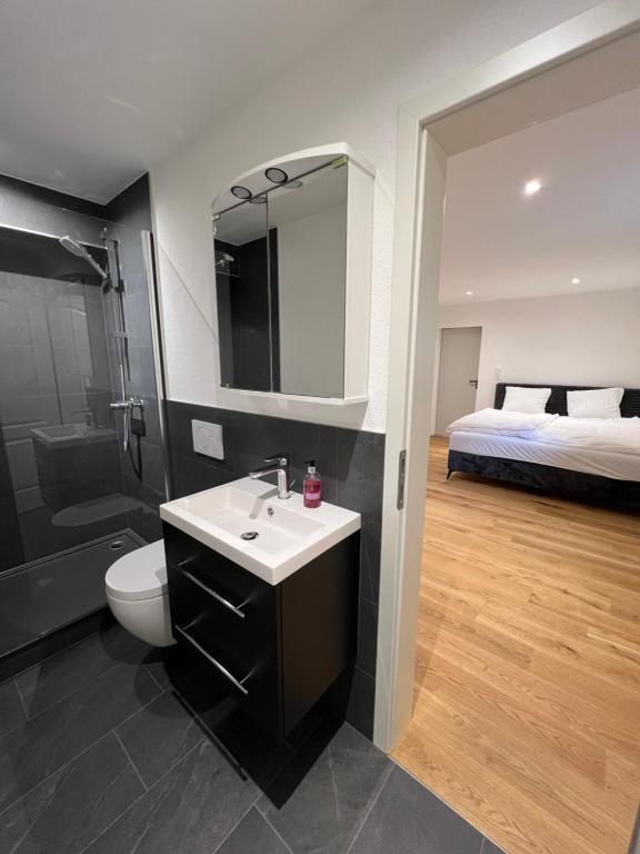 un bagno con lavandino, servizi igienici e un letto di Studio Glishorn Blick a Brig