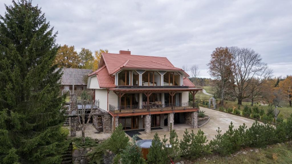 ein großes Haus mit rotem Dach in der Unterkunft Svirnelis in Medsėdžių