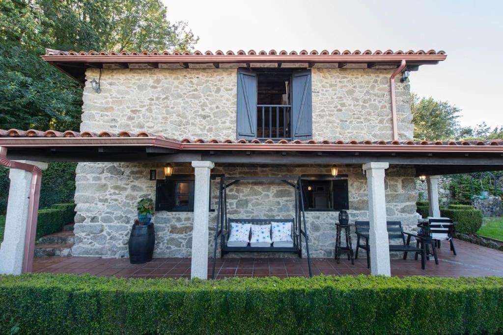 FerreiraにあるCasa con Piscina *Ribeira Sacra*のパティオ付きのデッキが備わる石造りの家です。