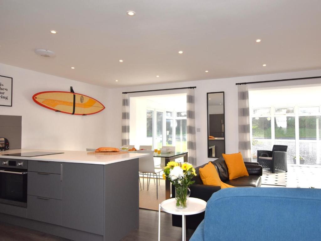 a kitchen and living room with a surfboard on the wall at 3 Bed in Widemouth Bay 86151 in Marhamchurch