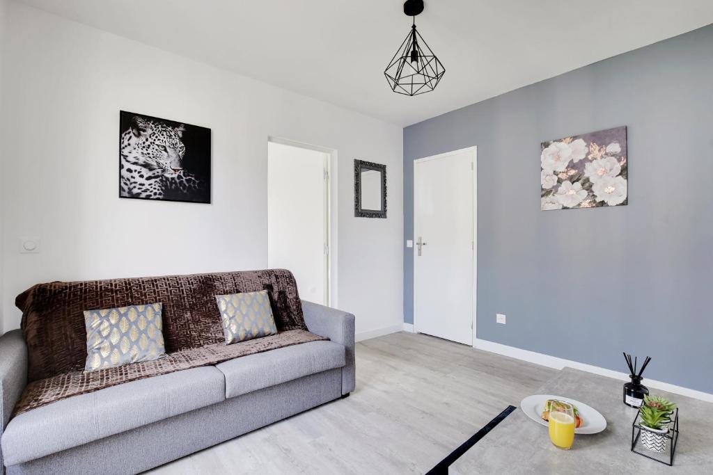 un salon avec un canapé et une table dans l'établissement Appartement Suite 43 aux Portes de Paris, à Aubervilliers