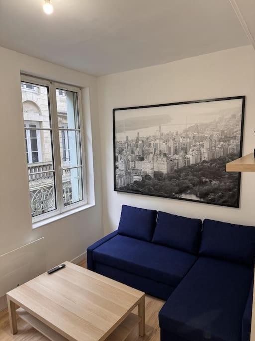 un salon avec un canapé bleu et une table dans l'établissement Vieux Marché - 1er Etage Rue, à Rouen