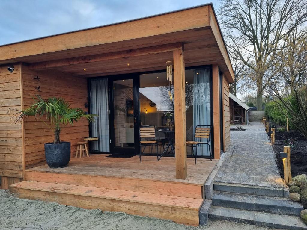 a wooden cabin with a porch with a potted plant at Chalet Musa in Musselkanaal