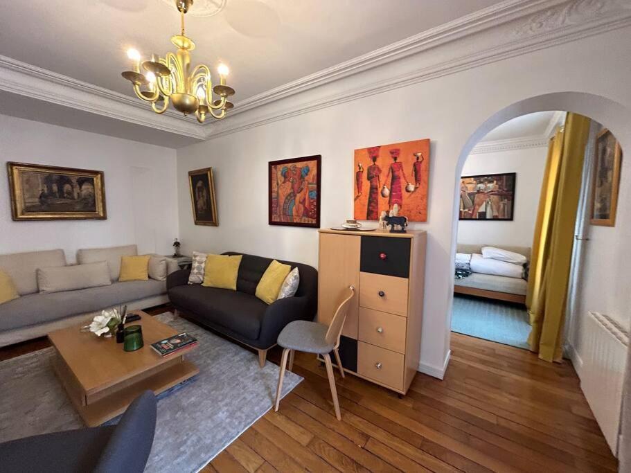 a living room with a couch and a table at Cosy Flat 2 BDR Arc de Triomphe Champs Elysées in Paris